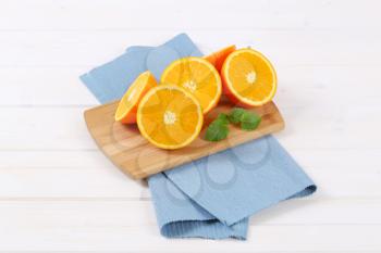 group of halved oranges on wooden cutting board
