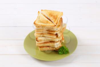 stack of toasted bread slices on green plate
