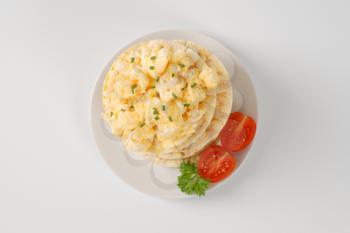 slices of puffed rice bread with scrambled eggs on white plate