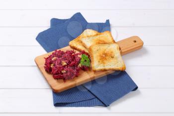 fresh beetroot spread with toast on wooden cutting board