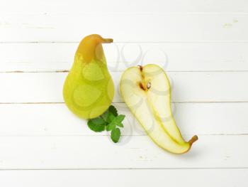 one and half pears on white wooden background