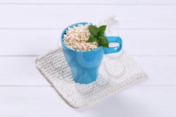 cup of puffed buckwheat on white table mat