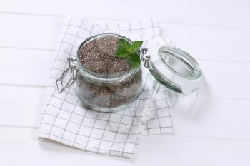 jar of chia seeds on checkered dishtowel