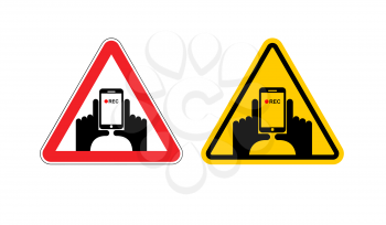 Warning sign of attention vertical video. Dangers yellow sign hand and smartphone. Set of road signs against shooting on phone. Note vertical record
