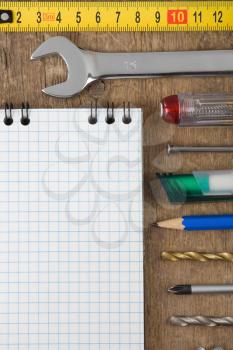 set of tools and notebook on wood background texture