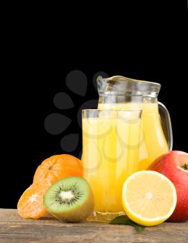 fresh fruits and juice in glass isolated on black background
