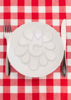 knife and fork at plate on napkin background