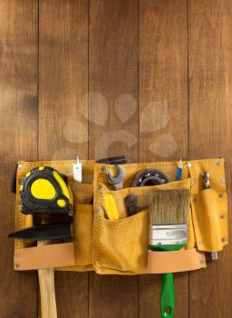 tools and instruments in belt on wooden background