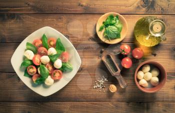 caprese salad and ingredients at wood