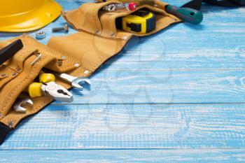 tools and instruments in belt on wooden table in front, plank board background texture surface