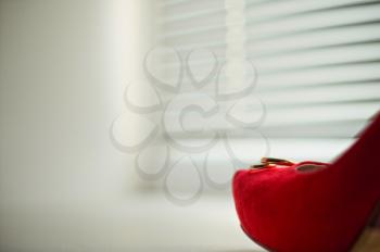 Red shoe on a window sill.