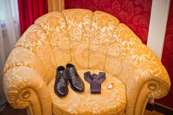 Smart chair with boots and a tie on it.