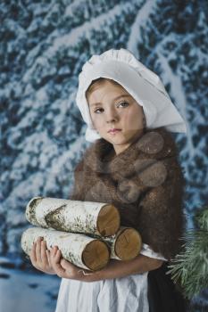 The child logs of firewood in a snowy forest.