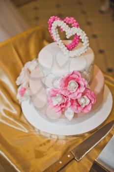 Sweet cake decorated with pink hearts and flowers.