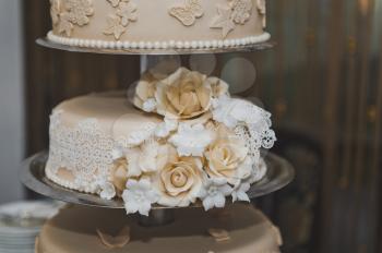 Wedding cake decorated with beige flowers from the cream.