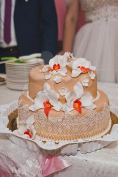 Wedding cake of two tiers decorated with flowers.