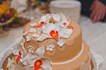 Beautiful beige cake decorated with flowers.
