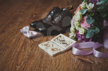 Wedding rings in a beautiful carved box and a colorful bouquet.