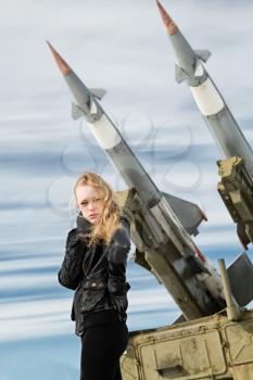 brutal girl stands amid battle tank