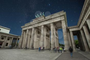 Brandenburg Gate - an architectural monument in the heart of Berlin's Mitte district. stars shine in the night sky.