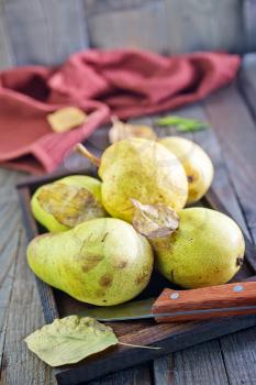 fresh pear on wooden tray and on a table