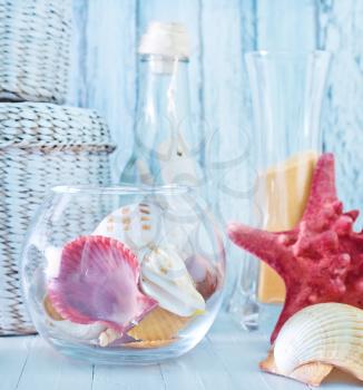 sea shells in glass bowl and on a table