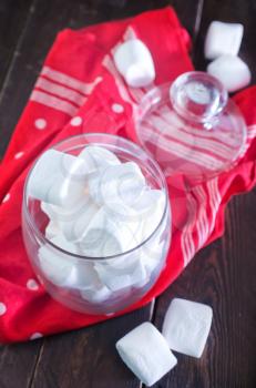 white marshmallows in glass bank and on a table