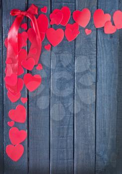 red hearts from paper on the wooden board