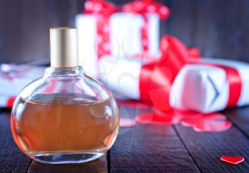 perfume in bottle and on the wooden table