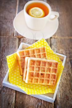 tea with lemon and sweet waffle on a table