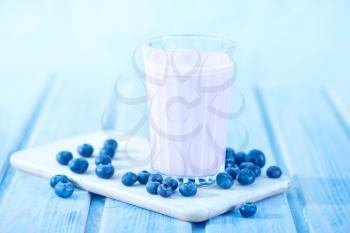 blueberry yogurt in glass and on a table