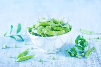 green peas on a table, fresh peas on the wooden background
