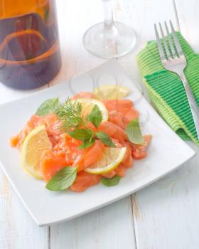 fresh salmon with lemon on the white plate