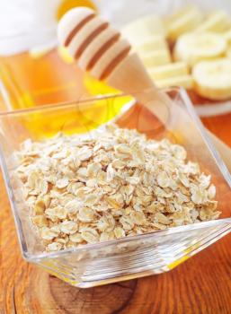 Raw oat flaks in the glass bowl
