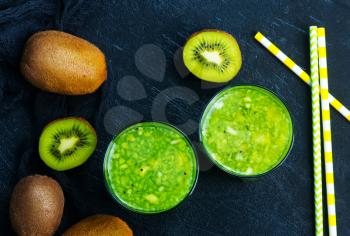 kiwi smoothie in glass and on a table