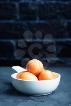 raw eggs in bowl and on a table