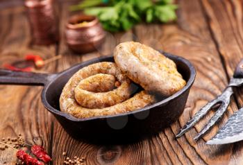 fried sausages in the pan and on a table