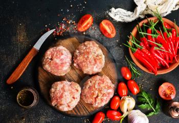 raw cutlets for burger on wooden board