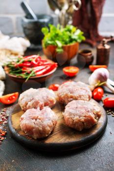 raw cutlets for burger on wooden board