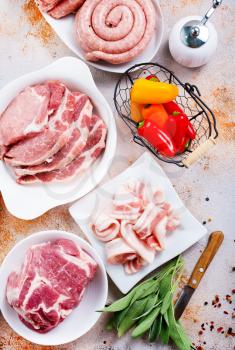 raw meat and raw sausages on the wooden board