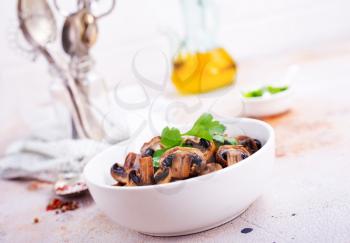  Vegan dish. Fried mushrooms and onion in the frying pan. European cuisine.