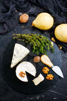 cheese with nuts and honey on wooden board