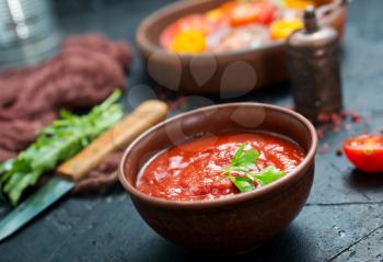 tomato sauce in bowl and fresh tomato on a table