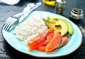 rice salmon avocado on plate on a table