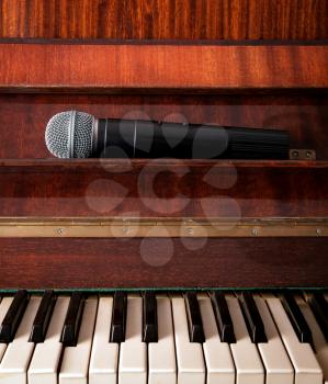 Old piano and wireless microphone close up