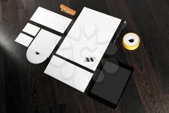 Photo of blank stationery and corporate identity template on dark wooden background. Blank stationery for design presentations and portfolios.