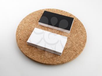 Black and white business cards on a round cork base.