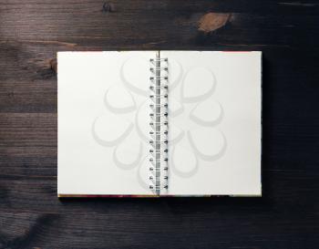 Blank notebook on dark wooden background. Spiral notepad on table. Flat lay.