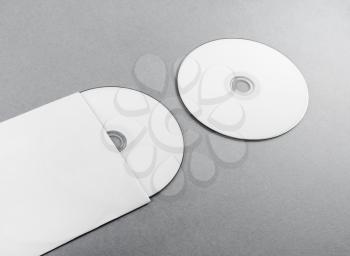 Blank compact disk on gray paper background. CD with envelope. Template for branding identity.