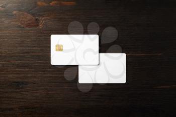 Photo of two blank bank cards on wooden background. Photo of white credit cards. Flat lay.